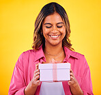 Happy woman, gift box and present for birthday, event or winning against a yellow studio background. Female person smile with prize, giveaway or celebration for surprise, package or ribbon parcel