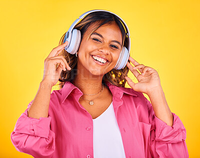 Buy stock photo Woman, headphones and listen to music in portrait, happiness and entertainment on yellow background, Fun, audio streaming and radio with rave or techno in studio, student with wireless tech and smile