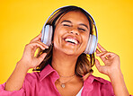 Headphones, excited and young woman in a studio listening to music, playlist or radio for entertainment. Happy, technology and female model from Mexico streaming a song or album by yellow background.