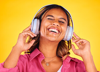 Buy stock photo Headphones, excited and young woman in a studio listening to music, playlist or radio for entertainment. Happy, technology and female model from Mexico streaming a song or album by yellow background.