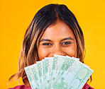 Woman, eyes and cash fan by face, financial freedom and wealth with winning bonus on yellow background. Money, finance with reward or prize from giveaway in studio, winner in portrait with cashback