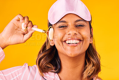 Buy stock photo Face roller, morning and portrait of woman with beauty skincare and smile isolated in studio yellow background for dermatology. Facial, detox and young person calm for care and relax with cosmetic