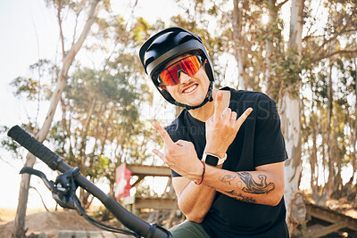 Buy stock photo Rock sign, bike and man with helmet in forest on off road cycling workout with happiness and glasses. Portrait, person and smile with hand gestures on bicycle for exercise, challenge and competition