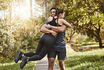Fitness, spinning and couple hug in park outdoors for exercise, training and running for cardio workout. Dating, happy and interracial man and woman embrace for wellness, healthy body and sports
