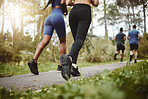 Back, legs and running with fitness friends in a park together for cardio training, health or wellness. Exercise, sports and workout with athlete people outdoor on a summer morning for a marathon run