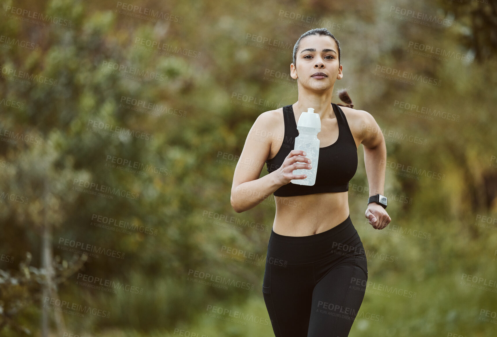 Buy stock photo Woman, water bottle and running in nature for fitness, workout or outdoor exercise with hydration. Active person, athlete or runner and natural mineral drink for training, nutrition or sustainability