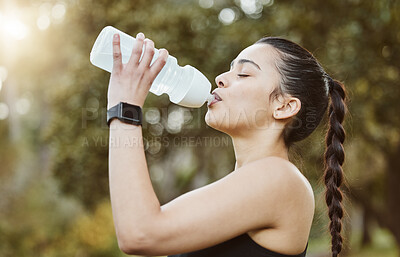 Buy stock photo Woman, fitness and drinking water in nature for hydration, natural nutrition or sustainability. Thirsty runner person with mineral drink or bottle in rest after workout, exercise or outdoor training