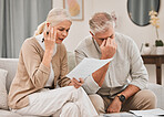 Married, couple and together with documents in frustration for finances, vacation or retirement at home. Elderly, man and woman on sofa with paperwork with bad news for plan, investments or budget 
