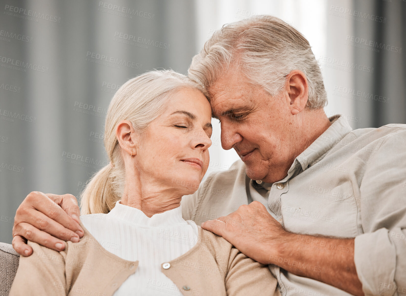 Buy stock photo Old people, hug and forehead touch, relax on sofa with love and support, bonding while at home with trust and comfort. Couple together in marriage, partner and retirement with calm and peace of mind