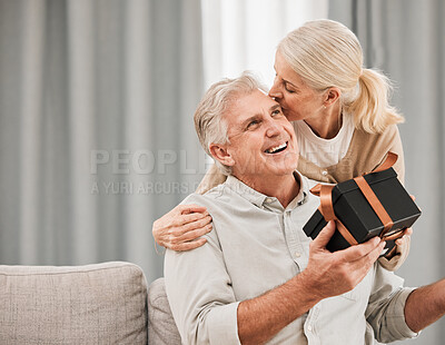 Buy stock photo Old couple, gift and birthday, kiss with love and surprise, man and woman at home, celebration and care. Happiness, present for anniversary with smile for special event and marriage with partner