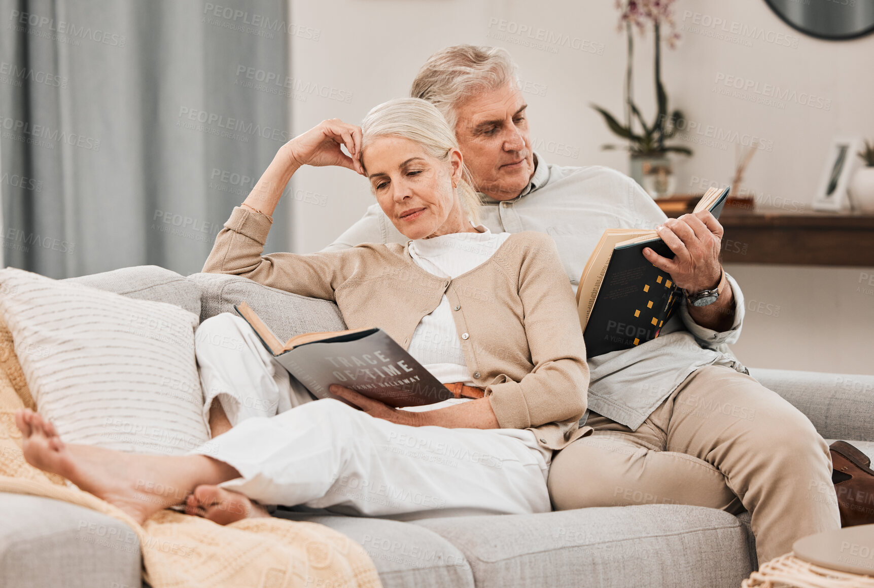 Buy stock photo Old people on couch, reading book and relax together at home, retirement and wellness with love and comfort. Trust, care and support in marriage, share hobby with partner for knowledge and story