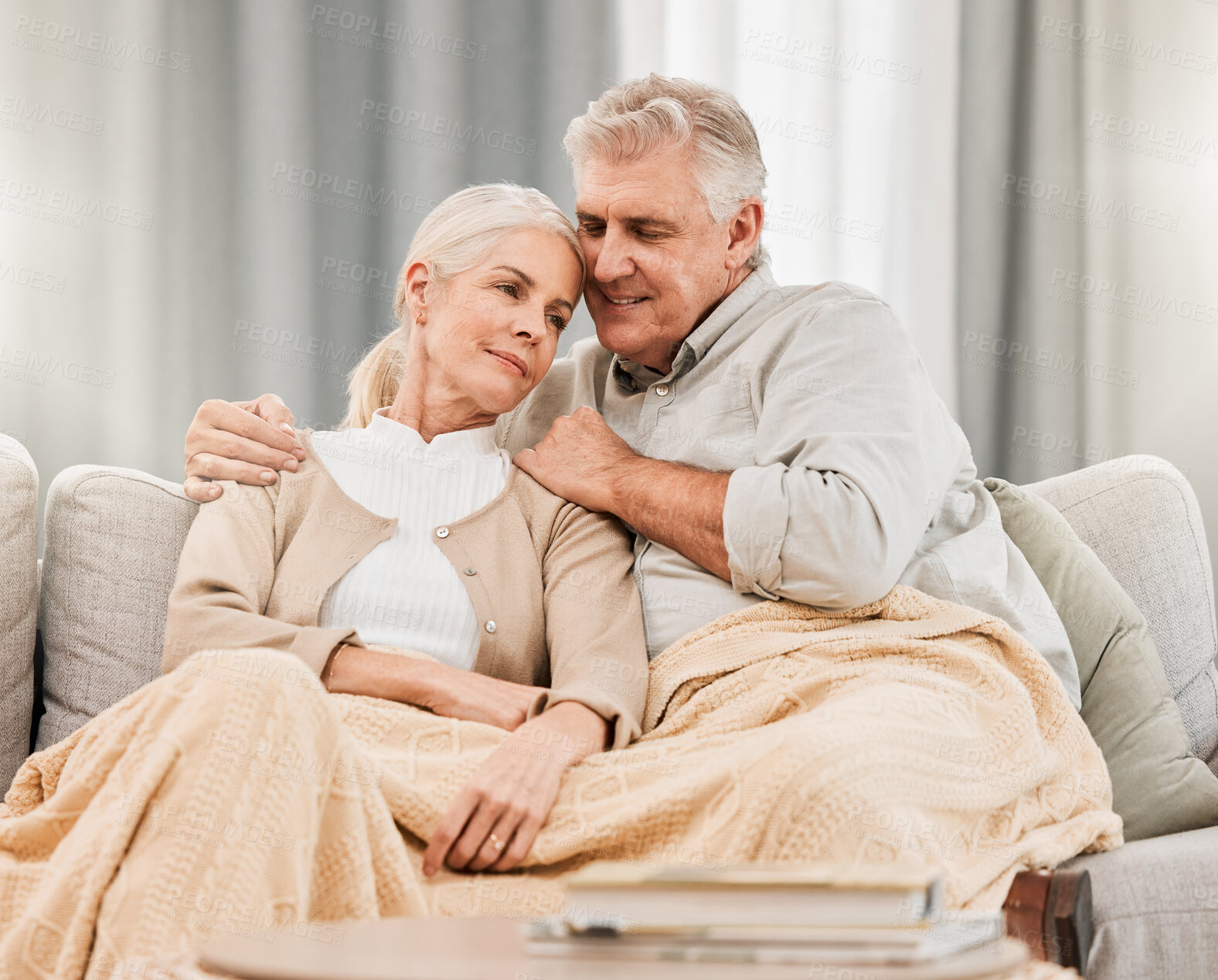 Buy stock photo Senior couple, bonding and care on a living room sofa with hug and relax at home. Elderly people, bonding and marriage love in retirement with blanket and calm in a lounge on a couch together