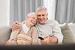 Senior couple, tv and laughing with love on a living room sofa with smile and movie at home. Elderly people, bonding and marriage in retirement with series and streaming in lounge on a couch together