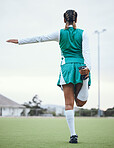 Back, balance and a woman hockey player stretching for the start of a game or competition outdoor. Sports, fitness and warm up with the legs of an athlete getting ready for training on a field