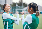 Hockey, fitness and women stretching in team training, practice or sports workout exercise on turf. Teamwork, smile or happy female athlete with flexibility ready to start a game in warm up together