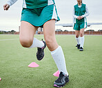 Cone, legs or team running for speed training, workout and warm up exercise on a outdoor hockey turf. Footwear closeup, balance or sports people on grass pitch playing in a practice game for fitness
