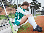  Woman, stress and headache at break, sport and worry in uniform, sportswear and gear on field. Athlete, burnout and anxiety in training from crisis or problem, fear and pressure in hockey and tired