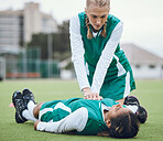 First aid, cpr and emergency with a hockey player on a field to save a player on her team after an accident. Fitness, training and heart attack with a woman helping her friend on a field of grass