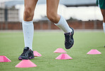 Cone, legs or athlete running in training, workout and warm up exercise on a outdoor hockey field or turf. Closeup, healthy or sports person on grass playing in a practice game for fitness speed