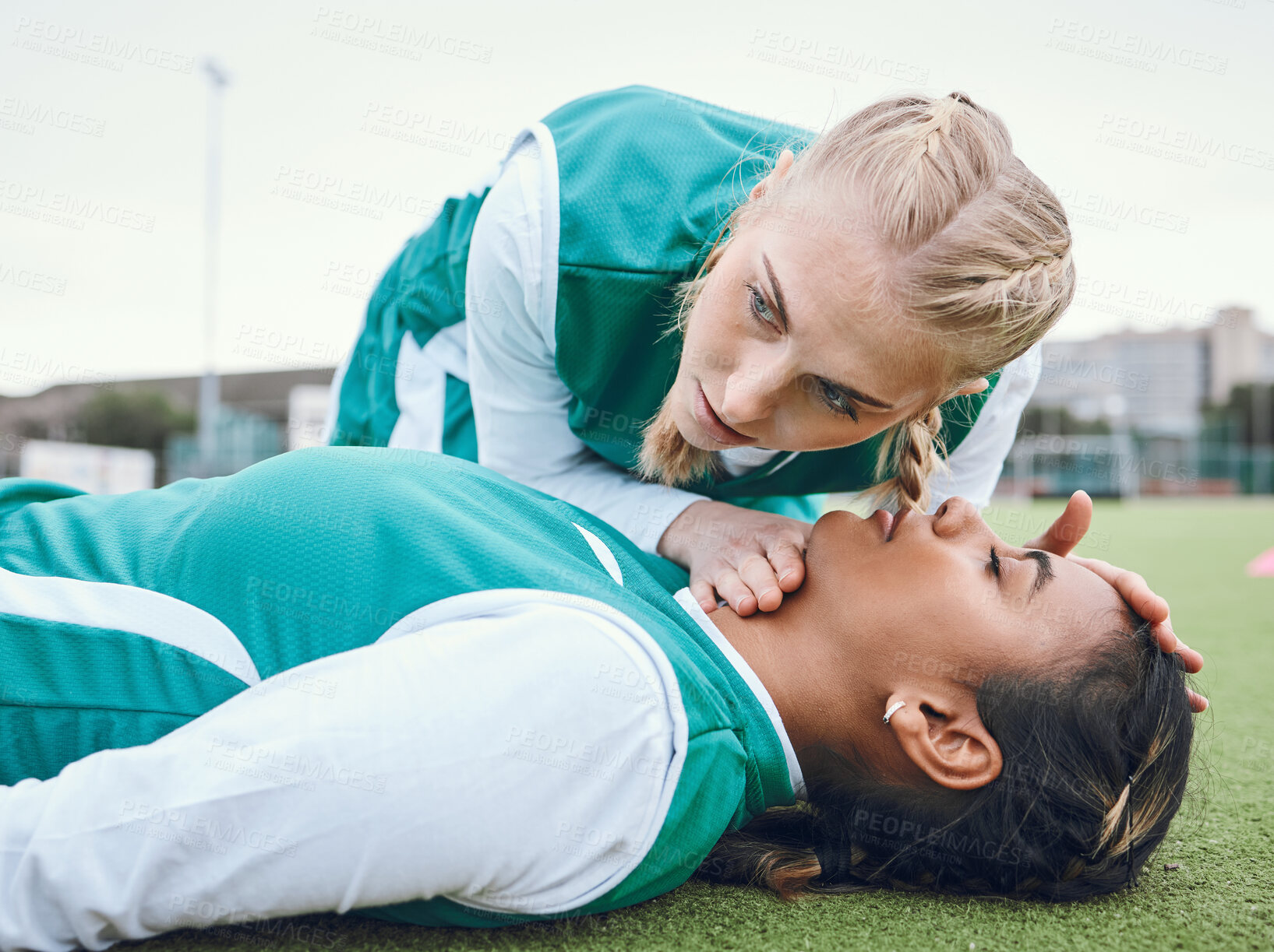 Buy stock photo First aid, cpr and breathing with a hockey player on a field to save a player on her team after an accident. Fitness, emergency and heart attack with a woman helping her friend on a field of grass