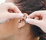 Closeup of hands, hearing aid and ear, person with disability and healthcare, people and medical audio tech for communication. Health, wellness and support, deaf and help with sound waves and implant