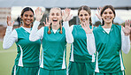Sports, women and team with hands for hello or wave with happiness on field outdoor for teamwork, training or workout. Football, group and girls with diversity and hi in nature for game or exercise