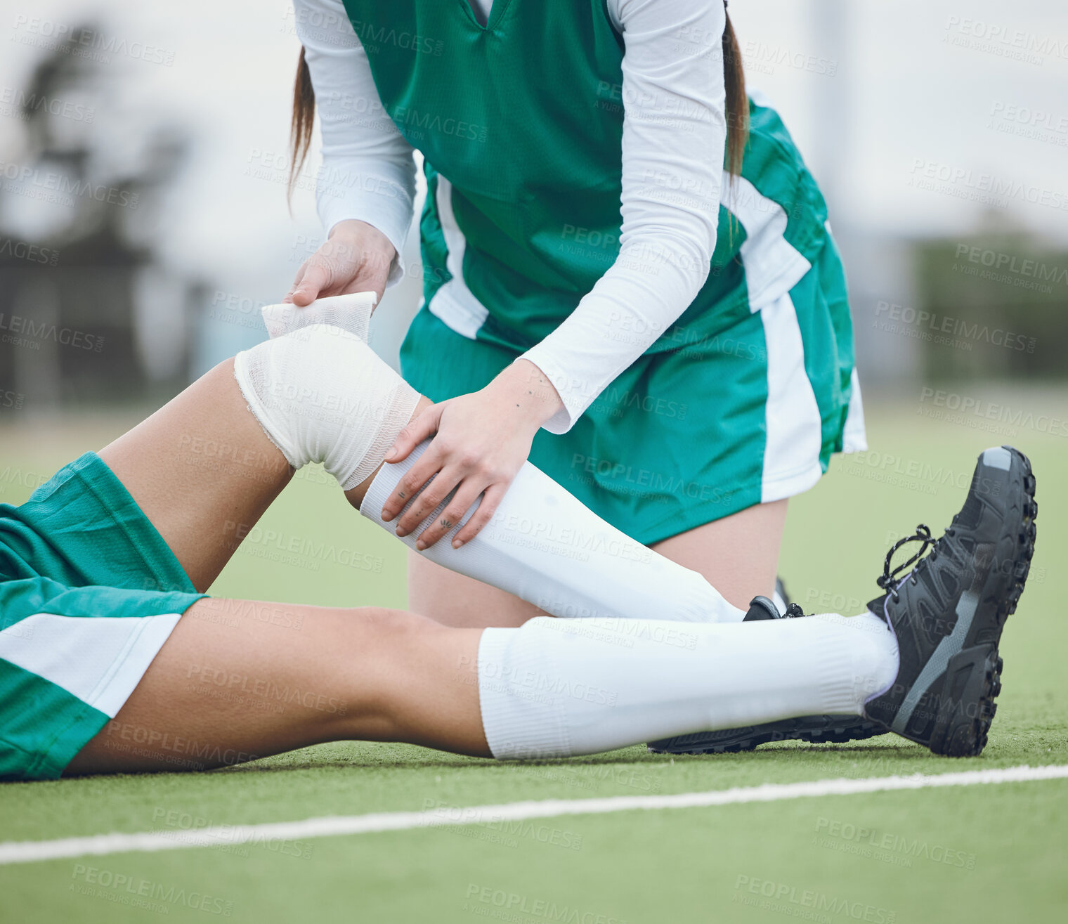 Buy stock photo Athlete, knee injury and help on field, sports and accident in sportswear. Person, emergency and first aid for joint pain, bruise and inflammation to bandage, broken by fall and suffering in game
