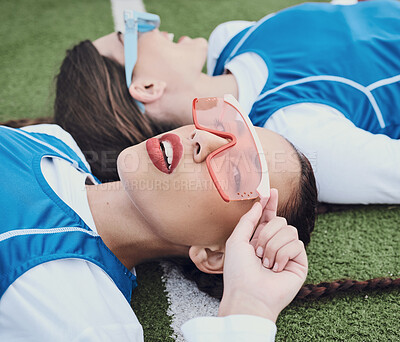 Buy stock photo Style, sports and women hockey players relaxing on the grass field with cool, stylish and trendy outfit. Fashion, fitness and portrait of female athlete friends laying in stadium after game or match.