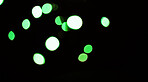 Bokeh on a dark background, green dots and sparkle with mockup space, abstract or wallpaper with special effects. Texture, pattern and glitter, graphics with glow or shine, disco with bubble decor