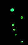 Green light, bokeh and glow on black background isolated on a mockup space. Blur, dark backdrop and defocused shine, sparkle or glitter at night for Christmas, holiday or party with magic color dots