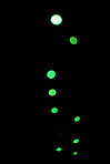 Green light, bokeh and glow on dark background isolated on a mockup space. Blur, black backdrop and defocused shine, sparkle or glitter at night for Christmas, holiday or party with magic color dots