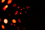 Red, lights and bokeh in a studio with dark background for celebration, event or party. Confetti, glitter and color sparkles for magic, shine or glow for festive by black backdrop with mockup.