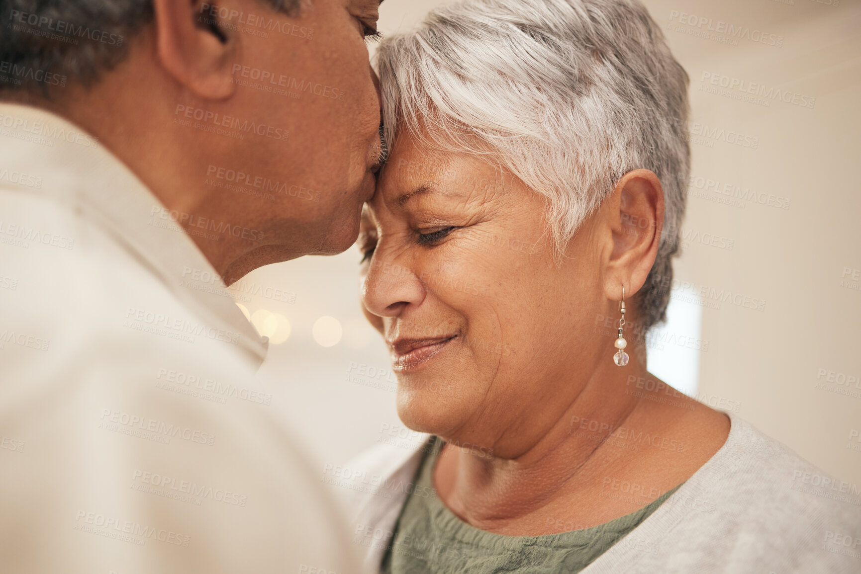 Buy stock photo Kiss, smile and senior couple in home with love, support and commitment to marriage in retirement. Embrace, face of happy man and old woman in apartment together with care, trust and romantic loyalty