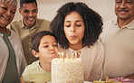 Happy birthday, big family and child with cake blowing candle in a home for event to celebrate together in a house. Grandparents, happiness and kid excited for gathering, surprise and gift