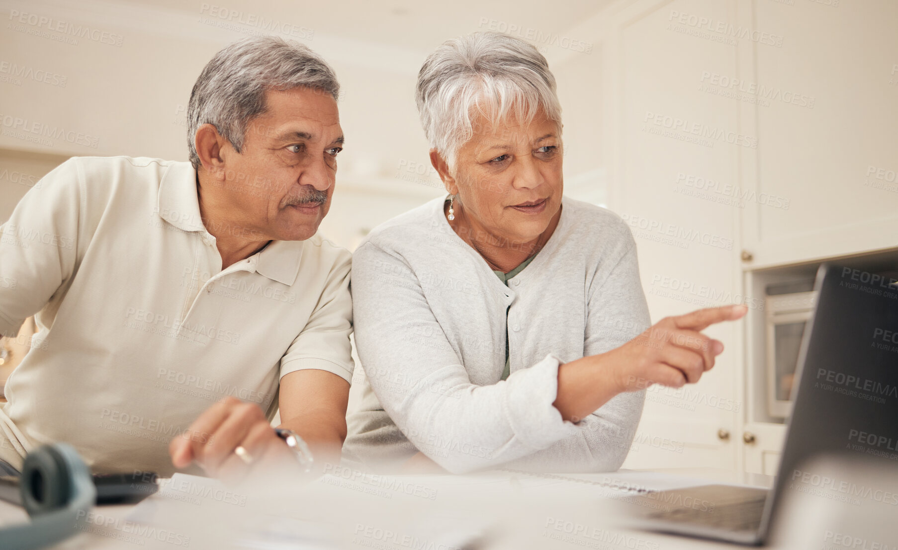 Buy stock photo Senior couple, laptop and pointing in budget planning, finance or retirement together at home. Mature man and woman in serious discussion or investment on computer with financial documents in kitchen