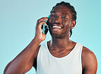 Phone call, communication and young black man in studio with smile for happy conversation. Technology, happiness and African male model on mobile discussion with cellphone isolated by blue background