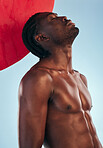 Art, body and black man thinking with style, creative graphic and red dot with fitness and workout in studio. Blue background, male model and fit muscle with skin glow, power and chest with profile