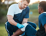 Sports, injury and man on field with bandage for accident, emergency and first aid for muscle sprain. Fitness, healthcare and medic with athlete with knee pain from exercise, workout and training