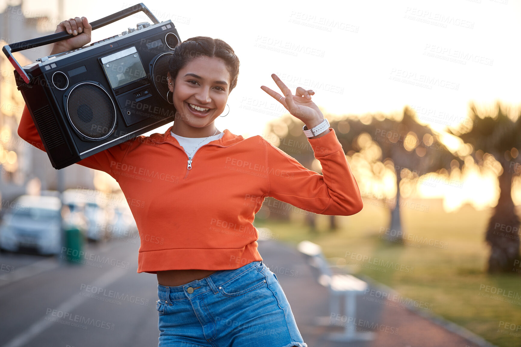 Buy stock photo Portrait, peace sign and woman with radio in the street for skating, happiness or fashion. Smile, walking and young girl with a stereo for music and gesture in the road in sunset for urban aesthetic