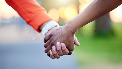 Buy stock photo Interracial couple, holding hands and love in nature for support, trust or unity together. Closeup of people touching in romance, care or friendship walk in an outdoor park for partnership or duo