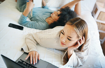 Buy stock photo Laptop, morning and a lesbian couple relaxing in bed while together in their home on the weekend. Computer, search and online with lgbt woman with her girlfriend in the bedroom for love or bonding