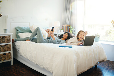 Buy stock photo Relax, technology and morning with a lesbian couple in the bedroom together in their home on the weekend. Diversity, smile and a happy young lgbt woman with her girlfriend in the bedroom for love