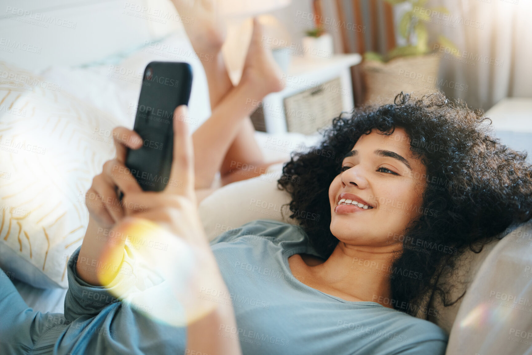 Buy stock photo Phone, relax and young woman on a bed networking on social media. mobile app or the internet. Happy, technology and female person from Mexico scroll on cellphone in her bedroom at modern apartment.