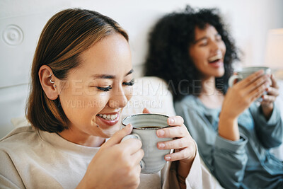 Buy stock photo Coffee, smile and lesbian couple on bed in conversation for bonding and relaxing together. Happy, rest and interracial lgbtq women laughing, talking and drinking latte in bedroom of modern apartment.