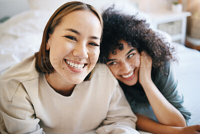 Buy stock photo Love, happy and portrait of lesbian couple relaxing on bed for bonding together on a weekend. Smile, romance and young interracial lgbtq women resting in the bedroom of modern apartment or home.