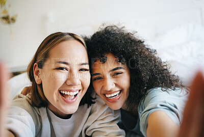 Buy stock photo Love, selfie and portrait of lesbian couple on bed for bonding, resting or relaxing together. Smile, happy and young interracial lgbtq women taking a picture in bedroom of modern apartment or home.