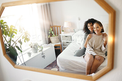 Buy stock photo Lesbian, couple and women sitting on bed with hug, love and commitment for together in cozy home. LGBTQ, relax and partner with happiness in apartment, bonding and reflection in bedroom mirror