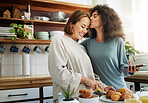 Lesbian, couple and kiss in kitchen with breakfast in morning together with nutrition, love and support in home. Lgbt, women or cooking with healthy food and preparing vegan diet on counter in house