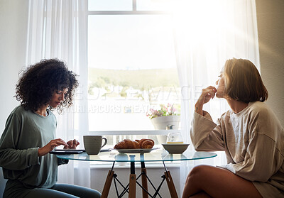 Buy stock photo Breakfast, lesbian couple on tablet in home and relax together, serious thinking and social media app. Technology, gay women and eating food at table in the morning, bonding and healthy relationship
