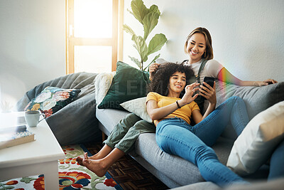 Buy stock photo Women, lgbt couple and smartphone on couch, living room and relaxing together for quality time, videos and bonding. Social media apps, indoors and smiling while streaming online, memes and cellphone